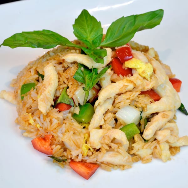 Chicken fried rice with red and green bell peppers, onions, scrambled egg, and basil.